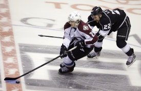 Colorado Avalanche center Nathan MacKinnon (29) skates by Los Angeles Kings center Trevor Lewis (22) during their NHL preseason hockey game Saturday, Oct. 4, 2014, in Las Vegas.