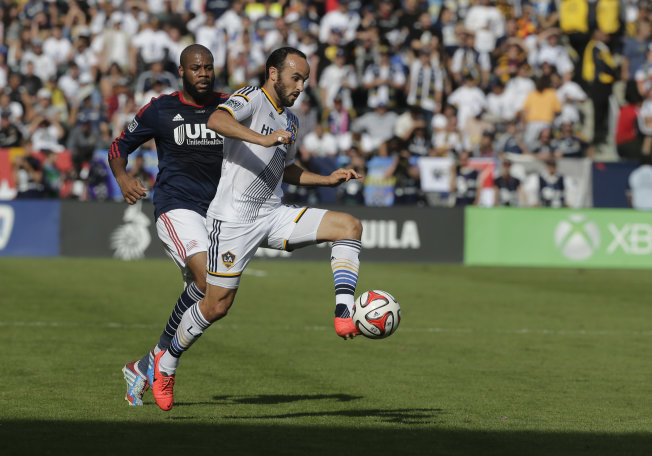 Los Angeles Galaxy's Landon Donovan, right, controls the ball past New England Revolution's Andrew Farrell during the first half of the MLS Cup championship soccer match Sunday, Dec. 7, 2014, in Carson, Calif. 